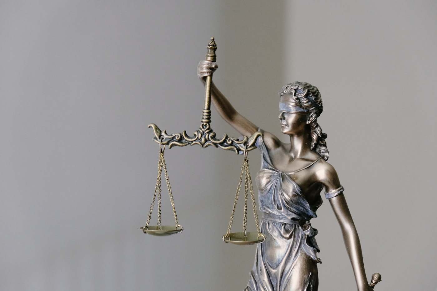 Lady Justice statue, scales of justice, and legal law books for trademark protection